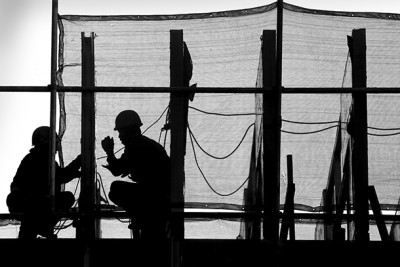 The silhouette of Chinese workers on a construction site in Beijing, China