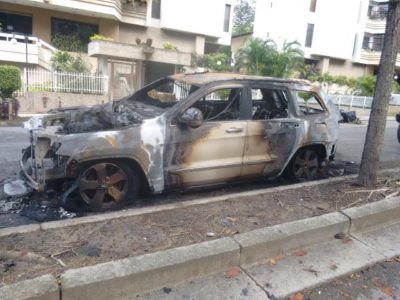 Um carro incendiado na rua onde vive Maritza